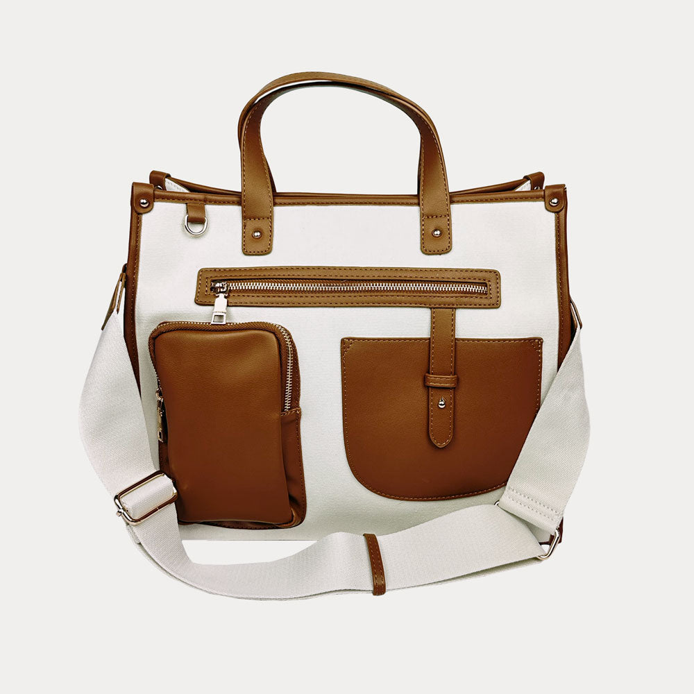 White tote bag with brown leather pockets and straps on a white background