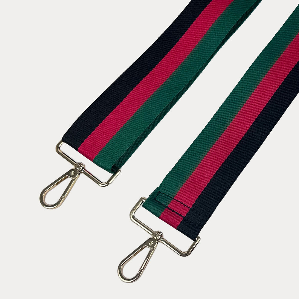 Black, red, and green striped bag strap with gold hardware on a light gray background,