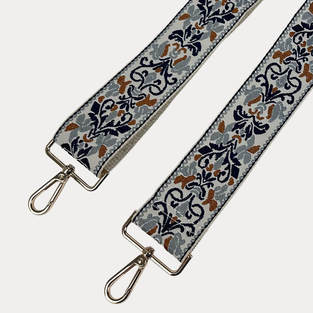 Cream ground Floral pattern bag strap with gold metal clasps on a light gray background