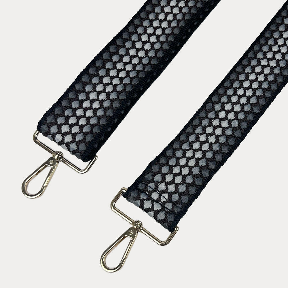 Black and gray patterned strap with gold metal clasps on a light gray background