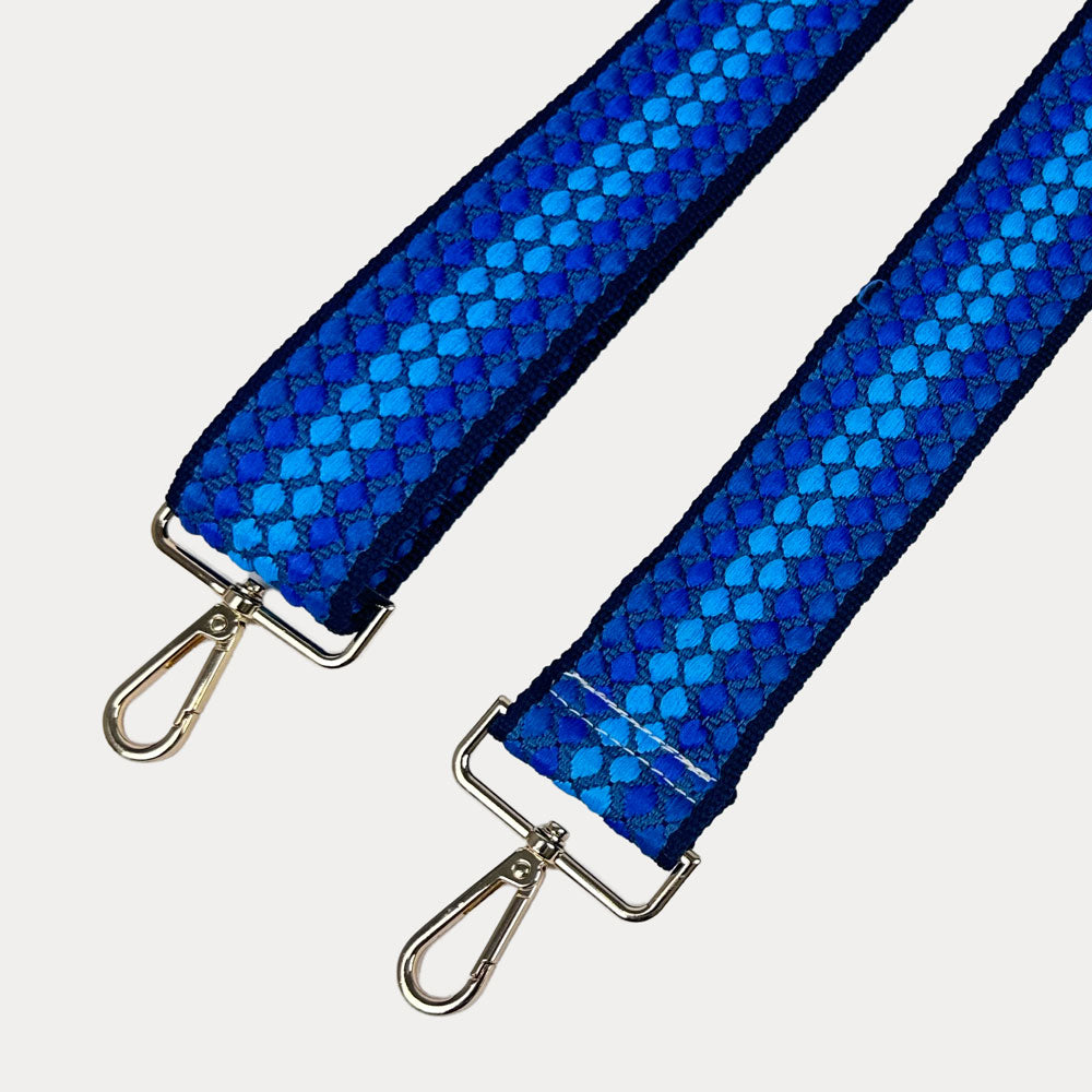 Royal Blue and Bright Blue patterned bag strap with gold metal clasps on a light gray background