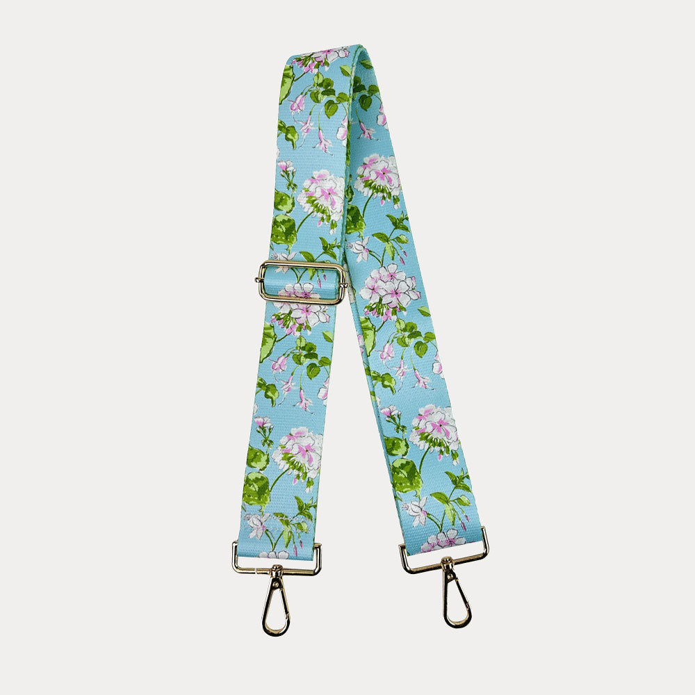 Aqua ground floral patterned strap with gold hardware on a light gray background