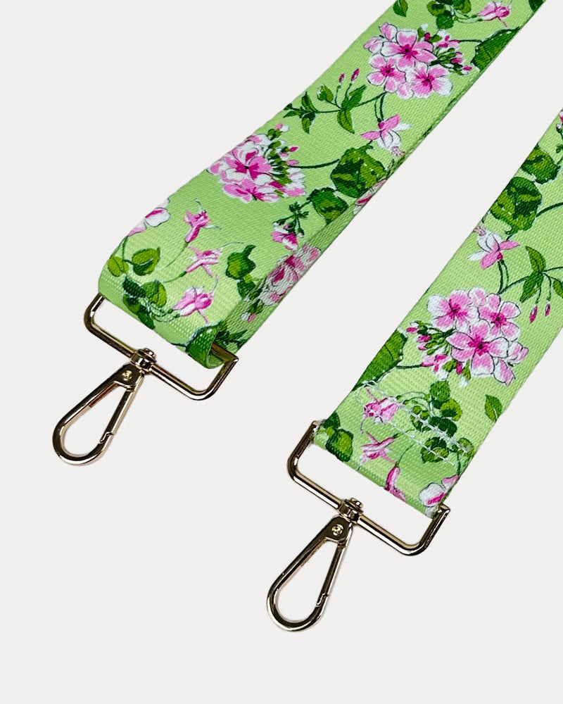 Lime ground floral patterned strap with gold hardware on a light gray background
