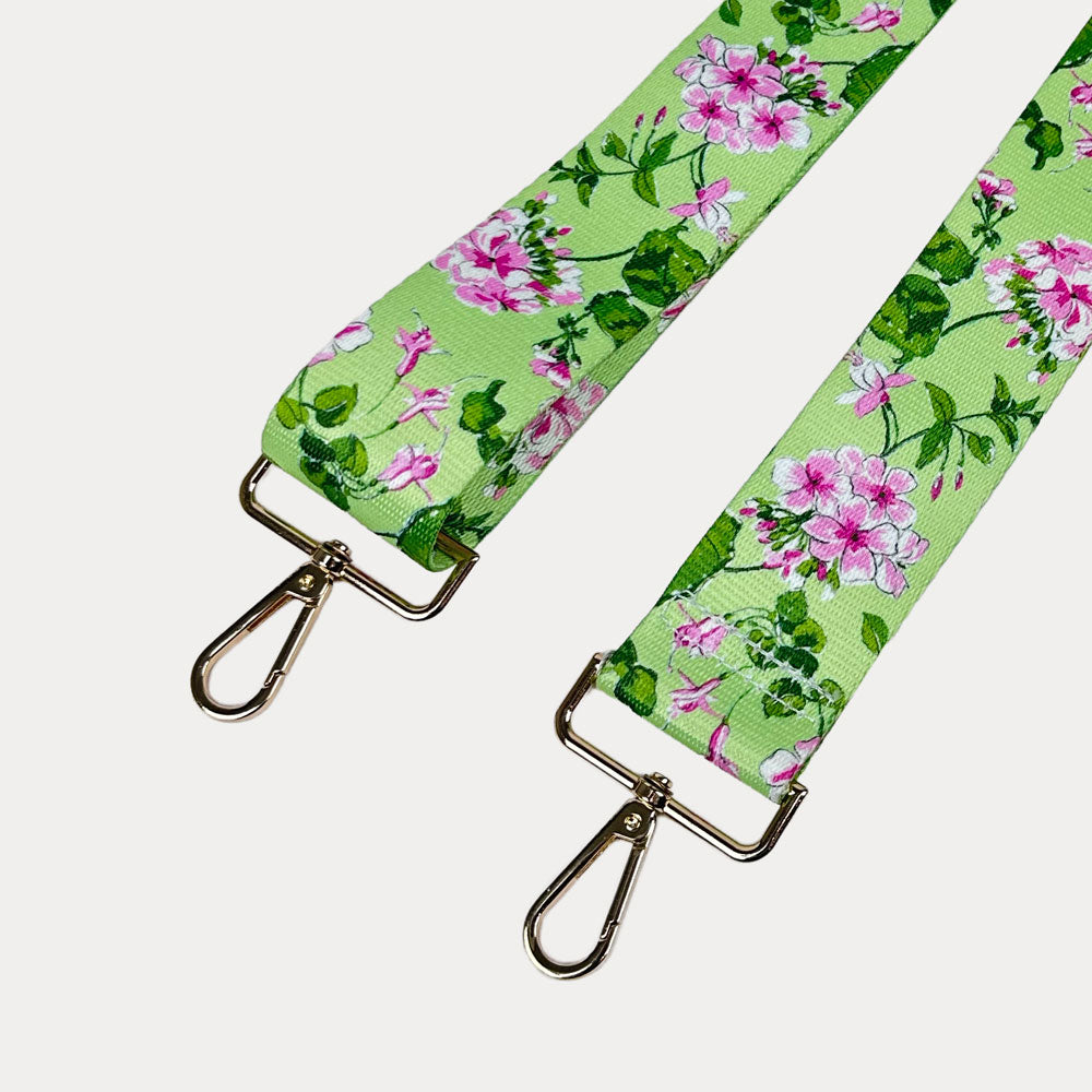 Lime ground floral patterned strap with gold hardware on a light gray background