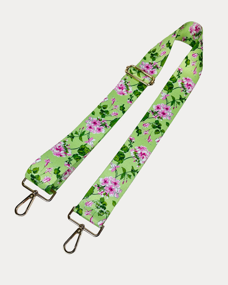 Lime ground floral patterned strap with gold hardware on a light gray background