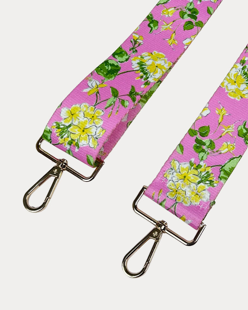 Pink ground floral patterned strap with gold hardware on a light gray background