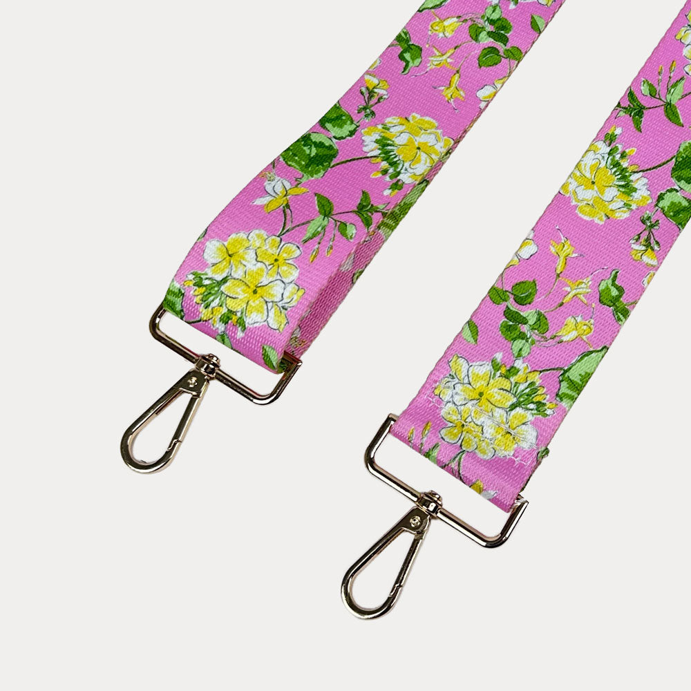 Pink ground floral patterned strap with gold hardware on a light gray background