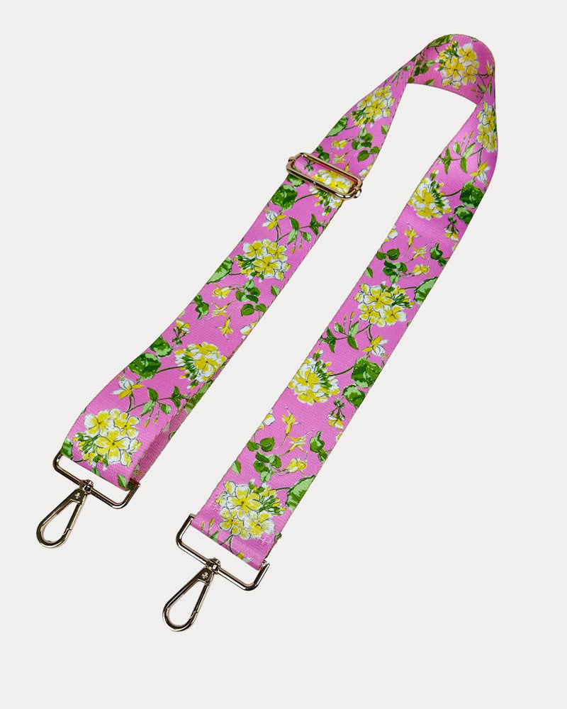 Pink ground floral patterned strap with gold hardware on a light gray background
