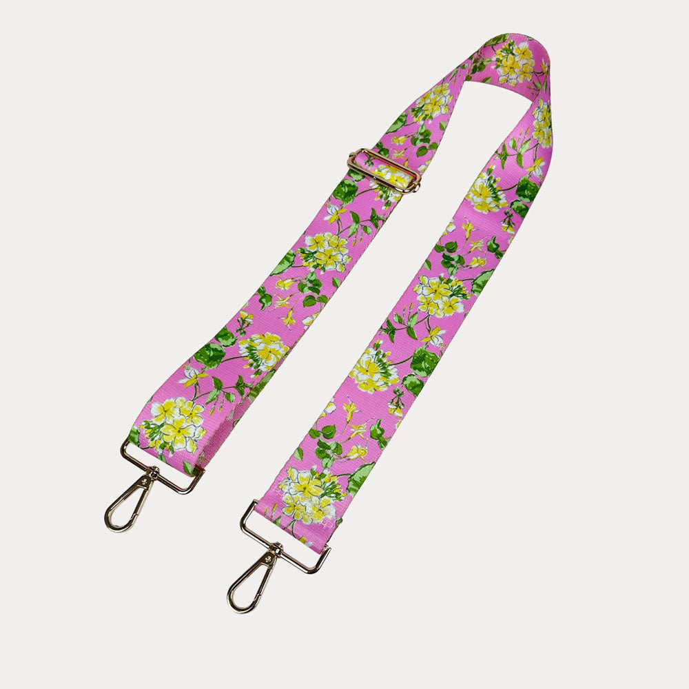 Pink ground floral patterned strap with gold hardware on a light gray background