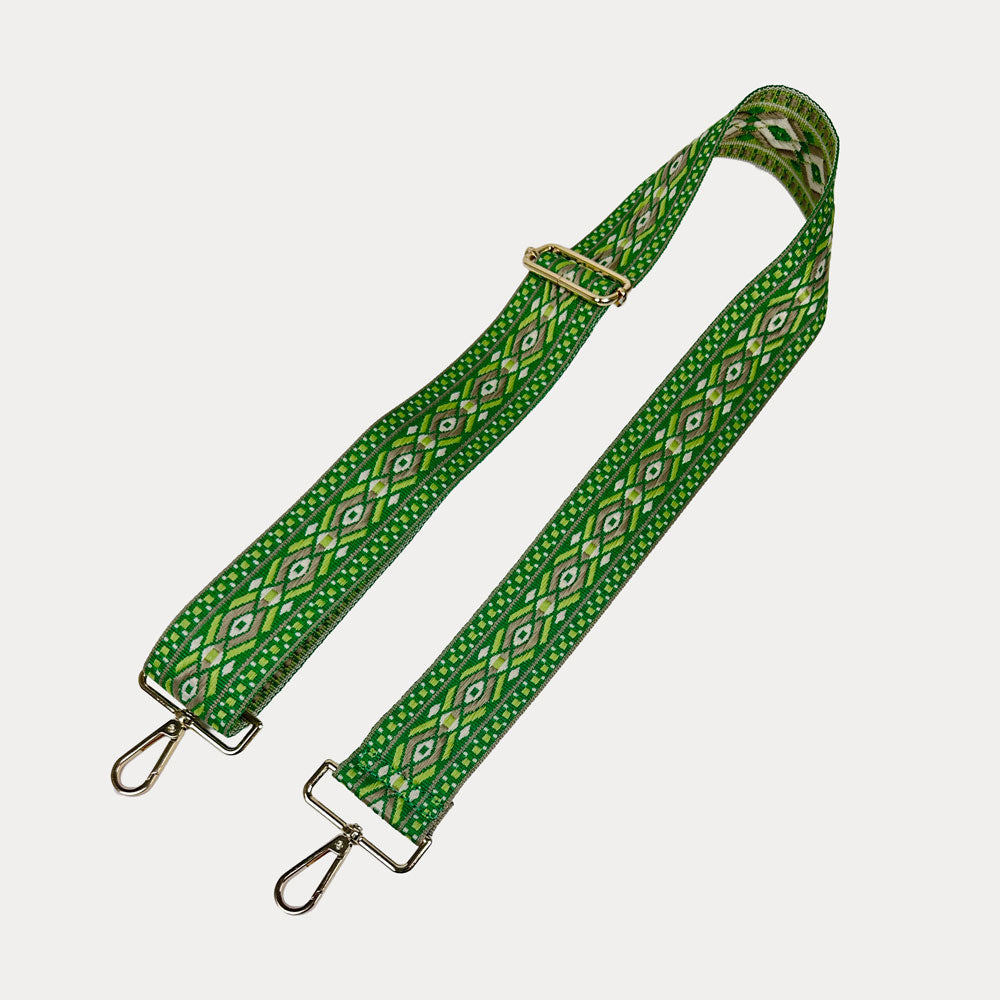 Green, light green, tan, diamond patterned bag strap with gold metal clasps on a light gray background