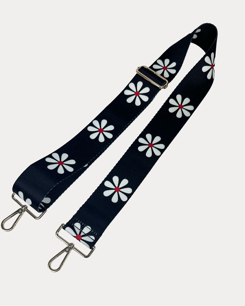Black ground with White Flower Print bag strap with gold metal clasps on light grey background