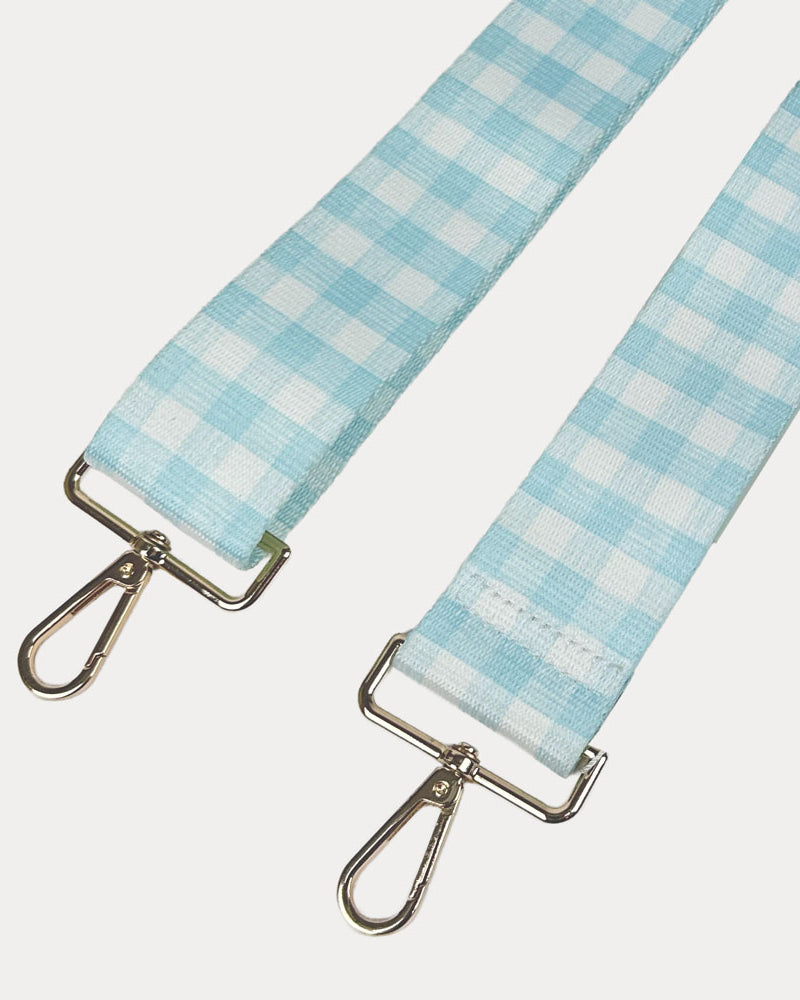Aqua and white checkered strap with gold metal clasps on a light gray background