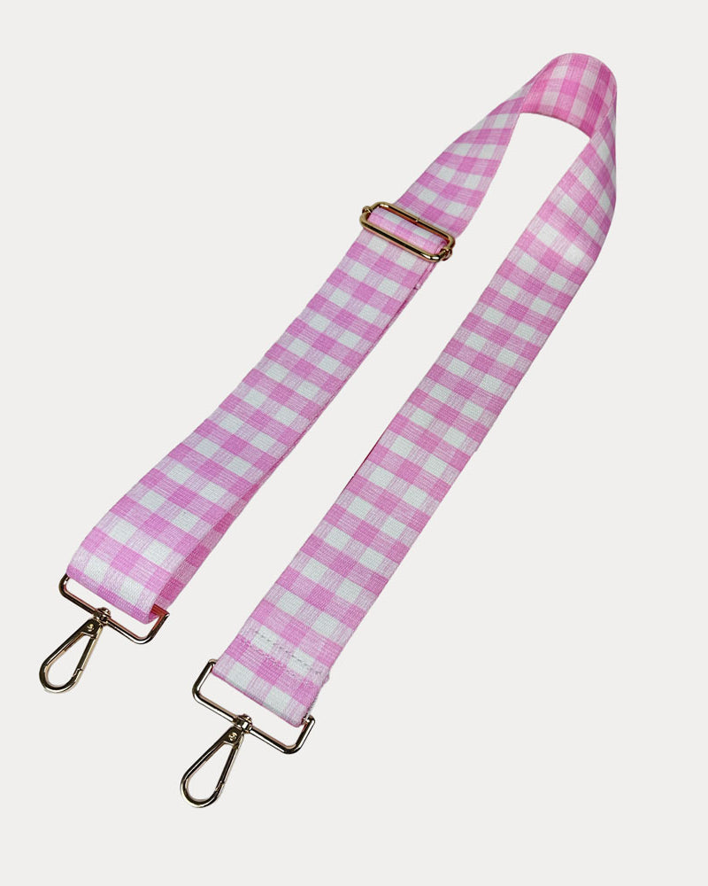 Pink and white checkered strap with gold metal clasps on a light gray background