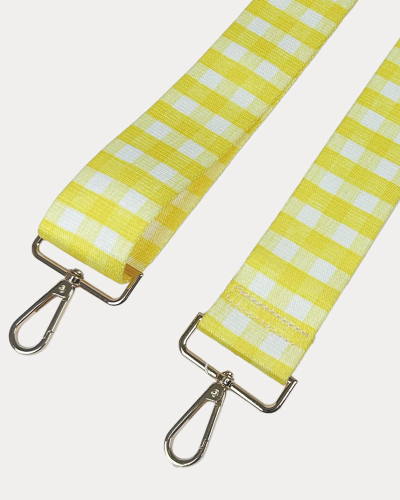 Yellow and white checkered strap with gold metal clasps on a light gray background