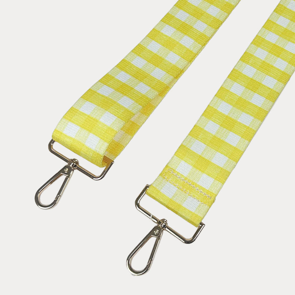 Yellow and white checkered strap with gold metal clasps on a light gray background