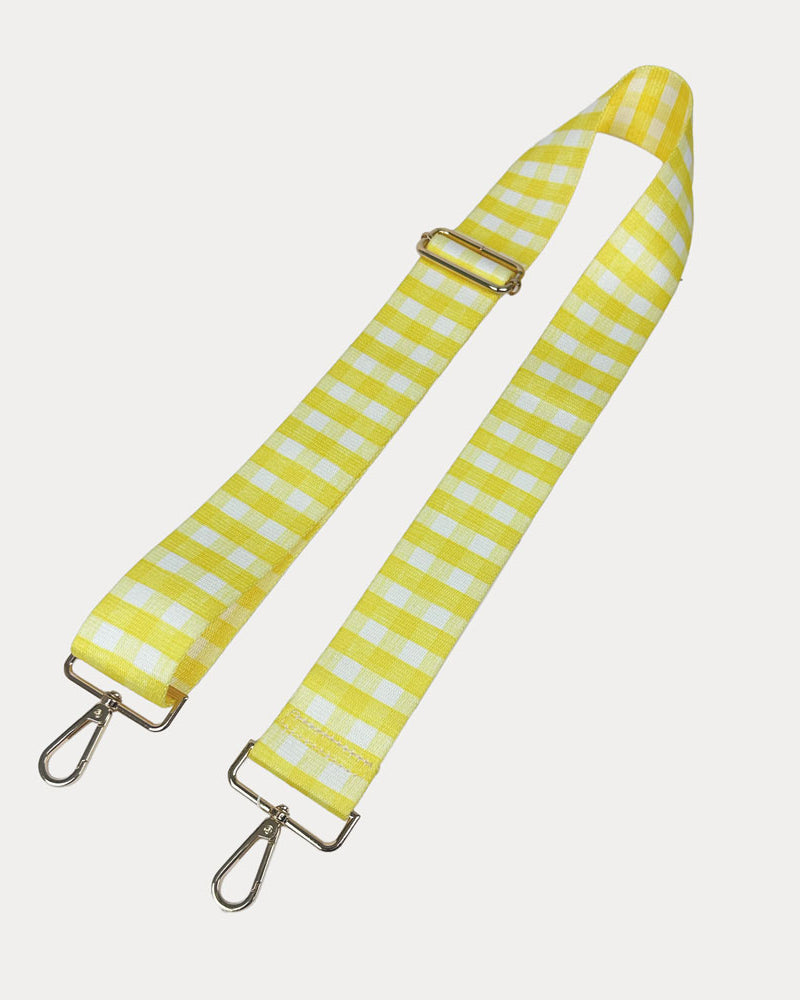 Yellow and white checkered strap with gold metal clasps on a light gray background