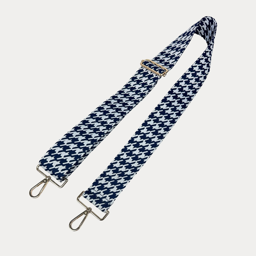 Navy and white houndstooth patterned strap with gold metal clasps on a light gray background