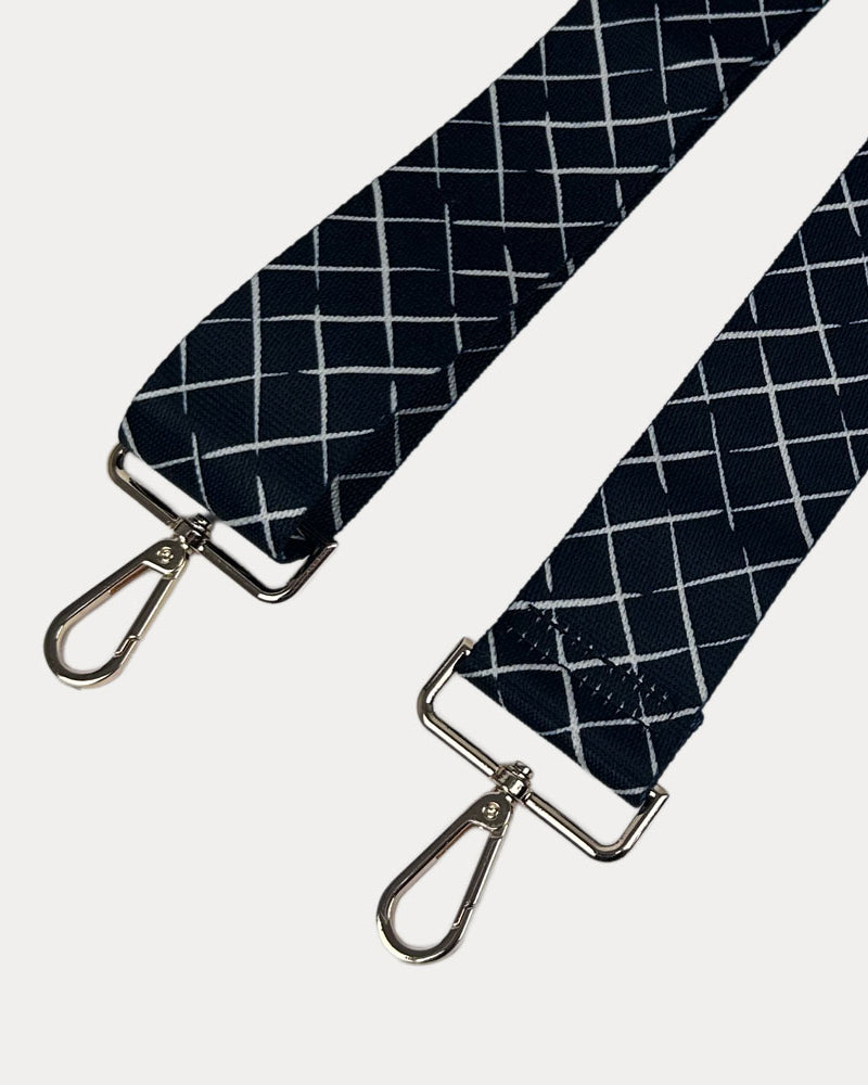Black and white patterned strap with gold hardware on a white background