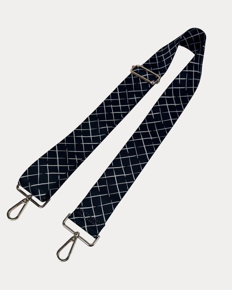Black and white patterned strap with gold hardware on a white background