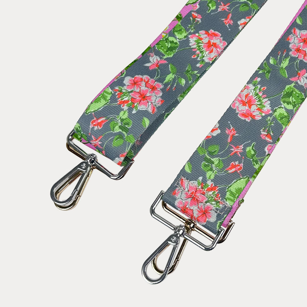 Grey ground floral patterned strap with silver hardware on a light gray background
