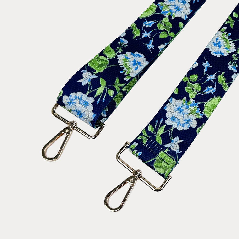 Navy ground floral patterned strap with gold hardware on a light gray background