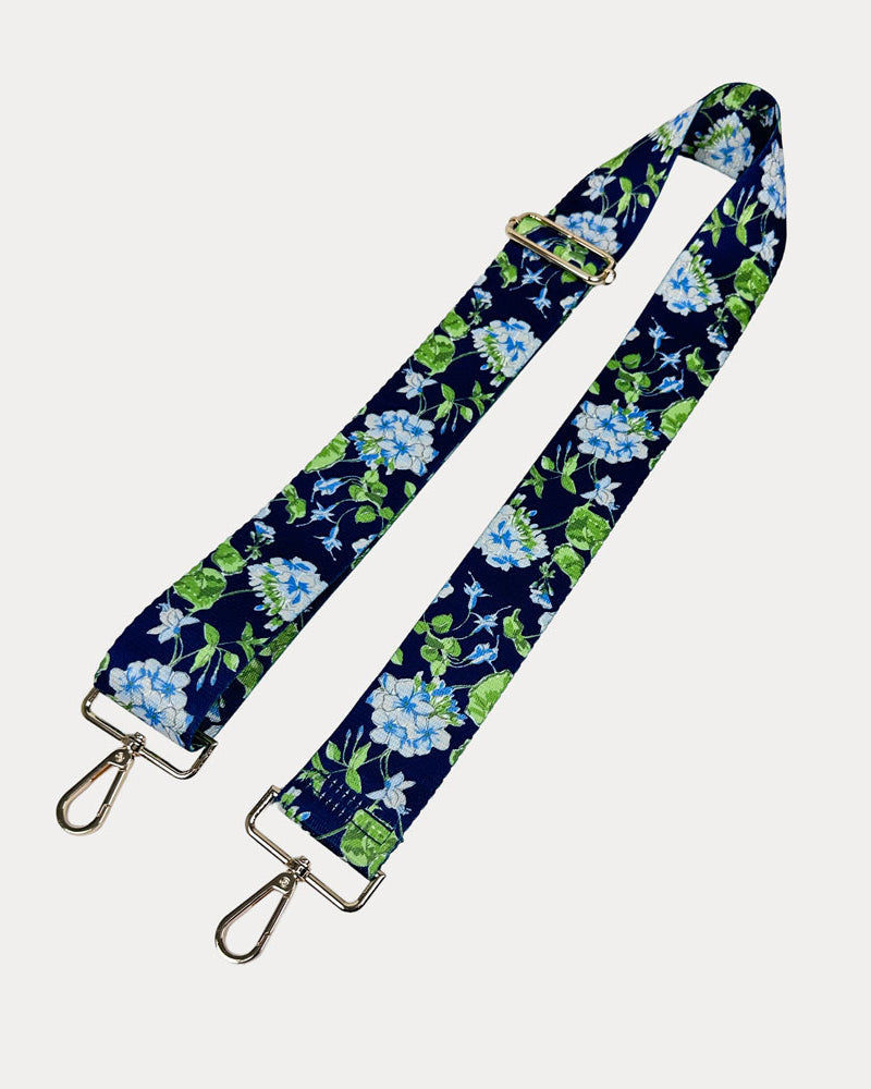 Navy ground floral patterned strap with gold hardware on a light gray background