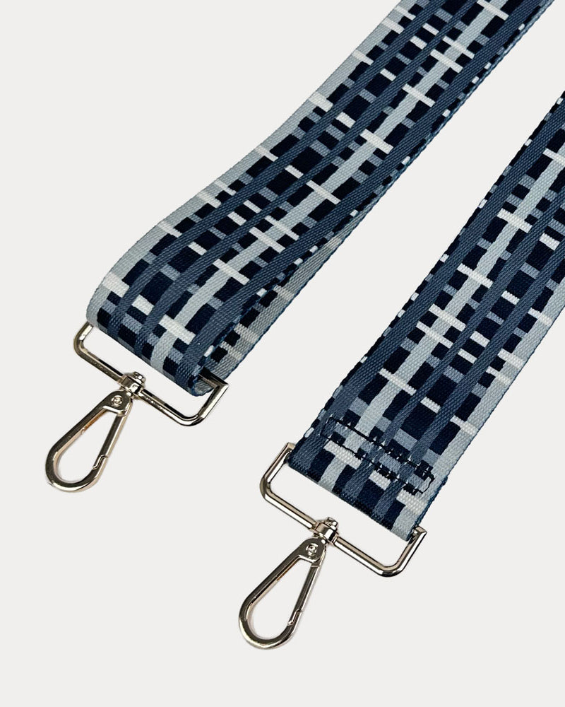 Black and grey plaid strap with gold metal hardware on a white background