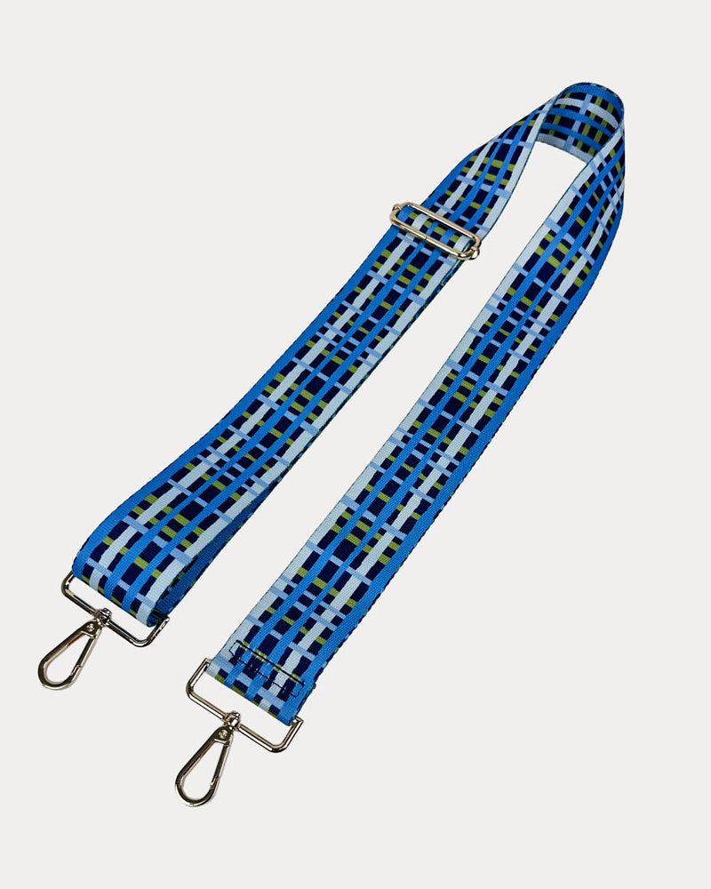 Navy, blue and green plaid strap with gold metal hardware on a white background