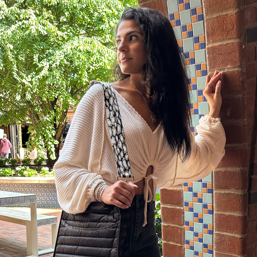 woman wearing the woven metallic gold, black, and white leopard bag strap
