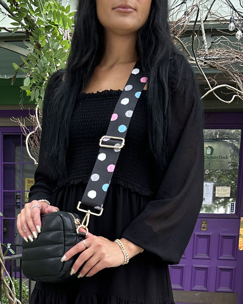 woman wearing the black with pastel colored polka dots printed bag strap