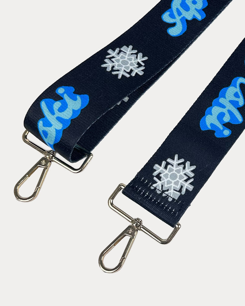 Black ground with Apres Ski text in Blue and white snowflakes printed bag strap with gold hardware
