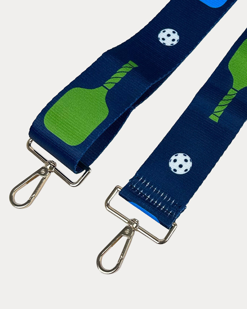 Navy ground with colorful pickleball paddles and white pickleball graphics with gold hardware bag strap