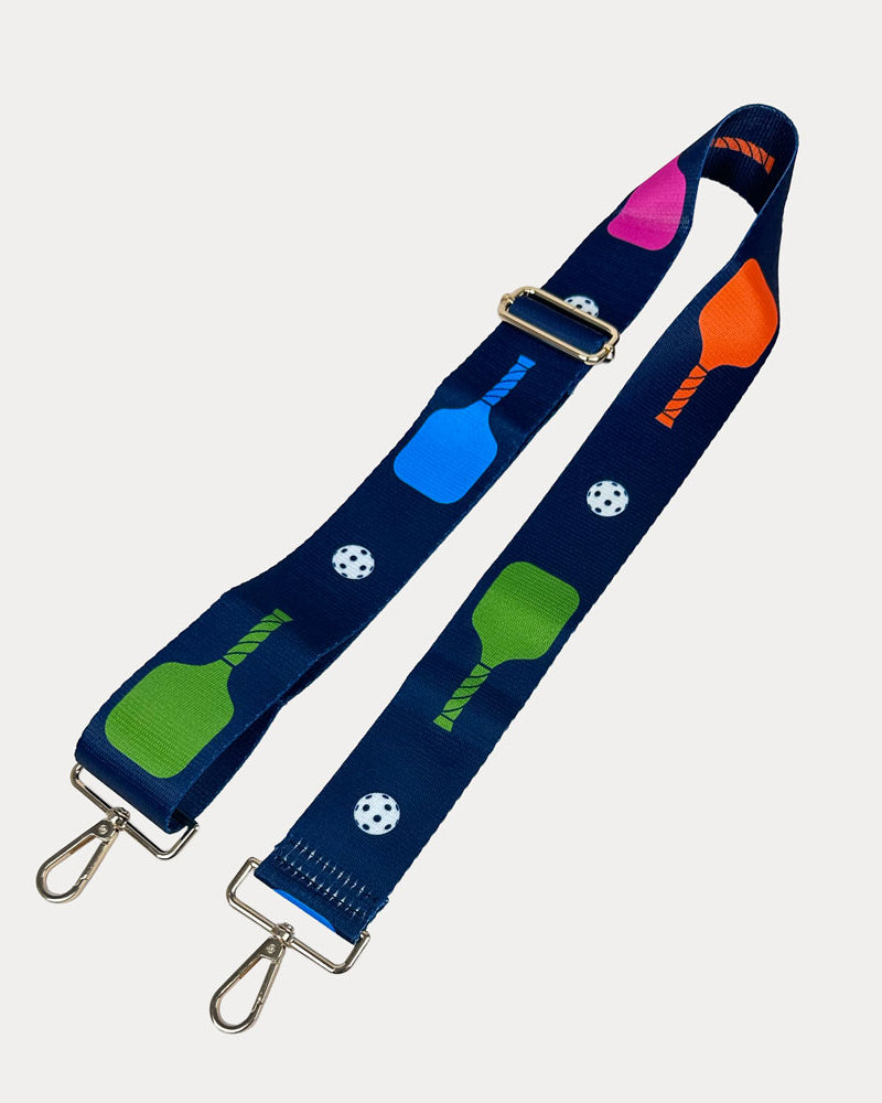Navy ground with colorful pickleball paddles and white pickleball graphics with gold hardware bag strap