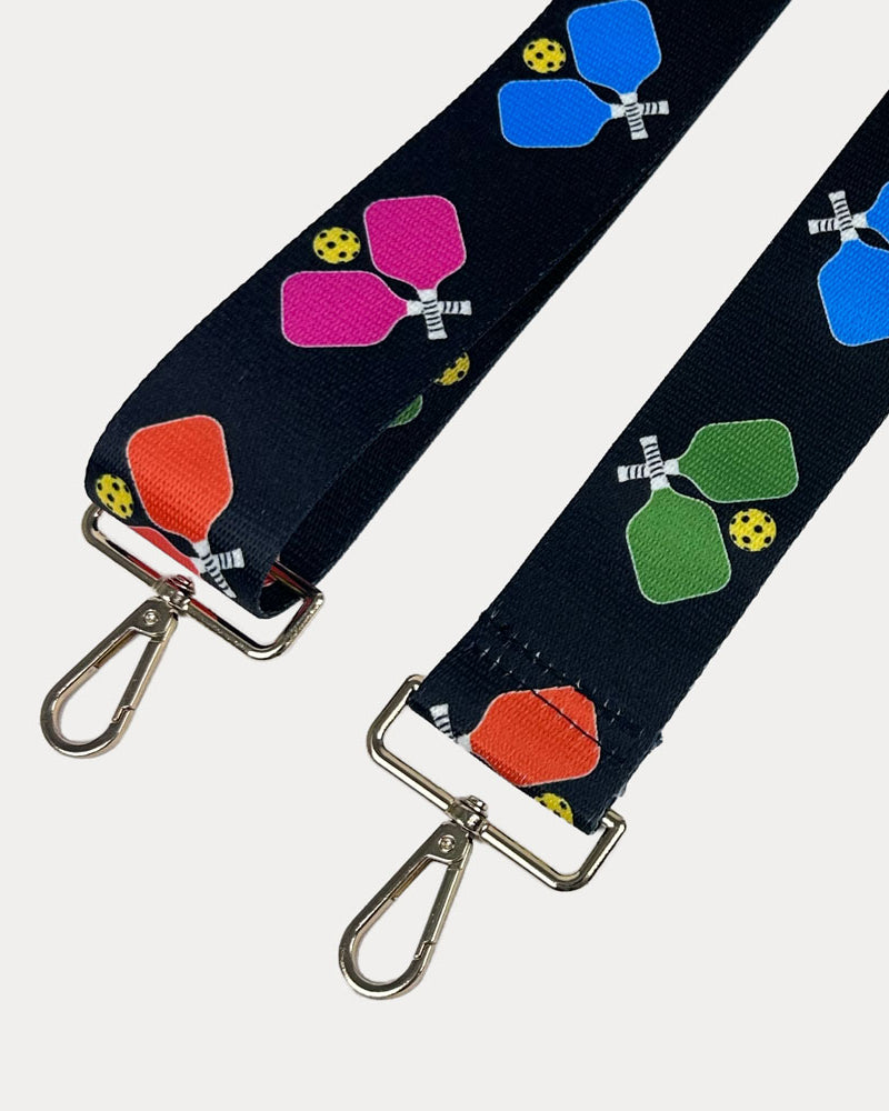 Black ground with colorful pickleball paddle graphics with gold hardware bag strap