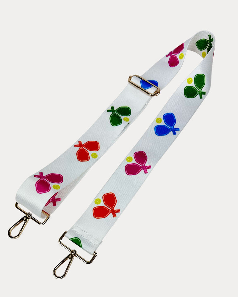 White ground with colorful pickleball paddle graphics with gold hardware bag strap