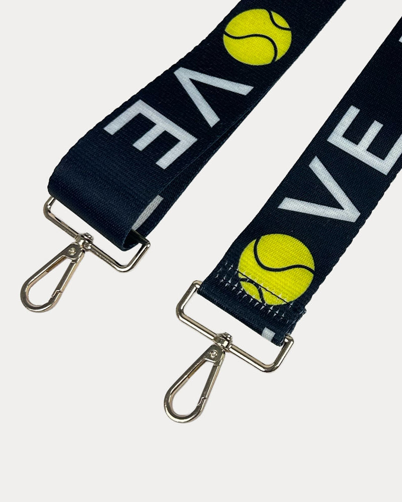 Black ground with 'LOVE' text and tennis ball graphics with gold hardware bag strap