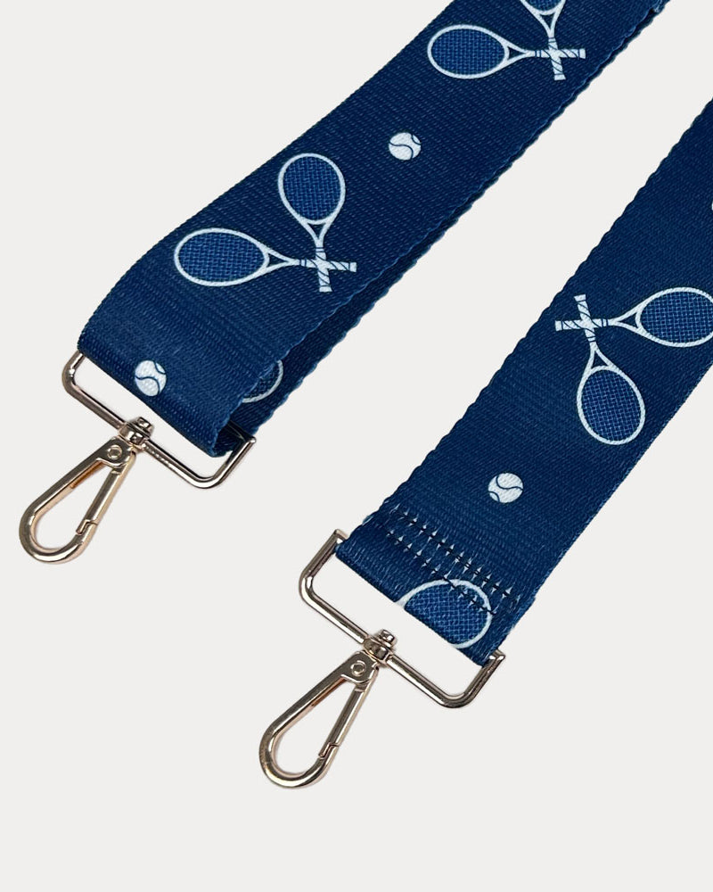 Navy ground with tennis racket graphics with gold hardware bag strap