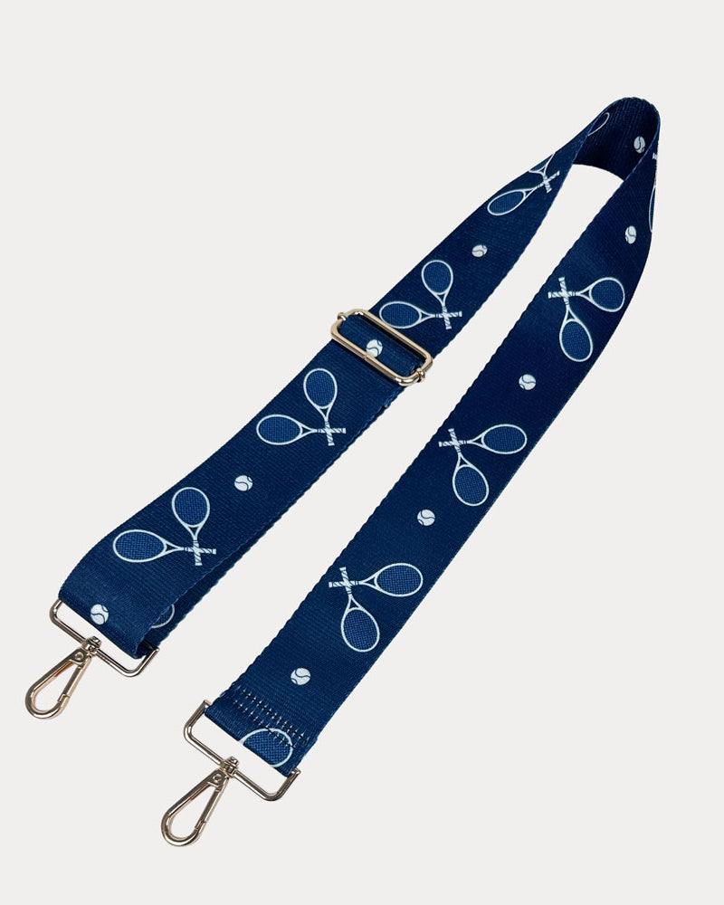 Navy ground with tennis racket graphics with gold hardware bag strap