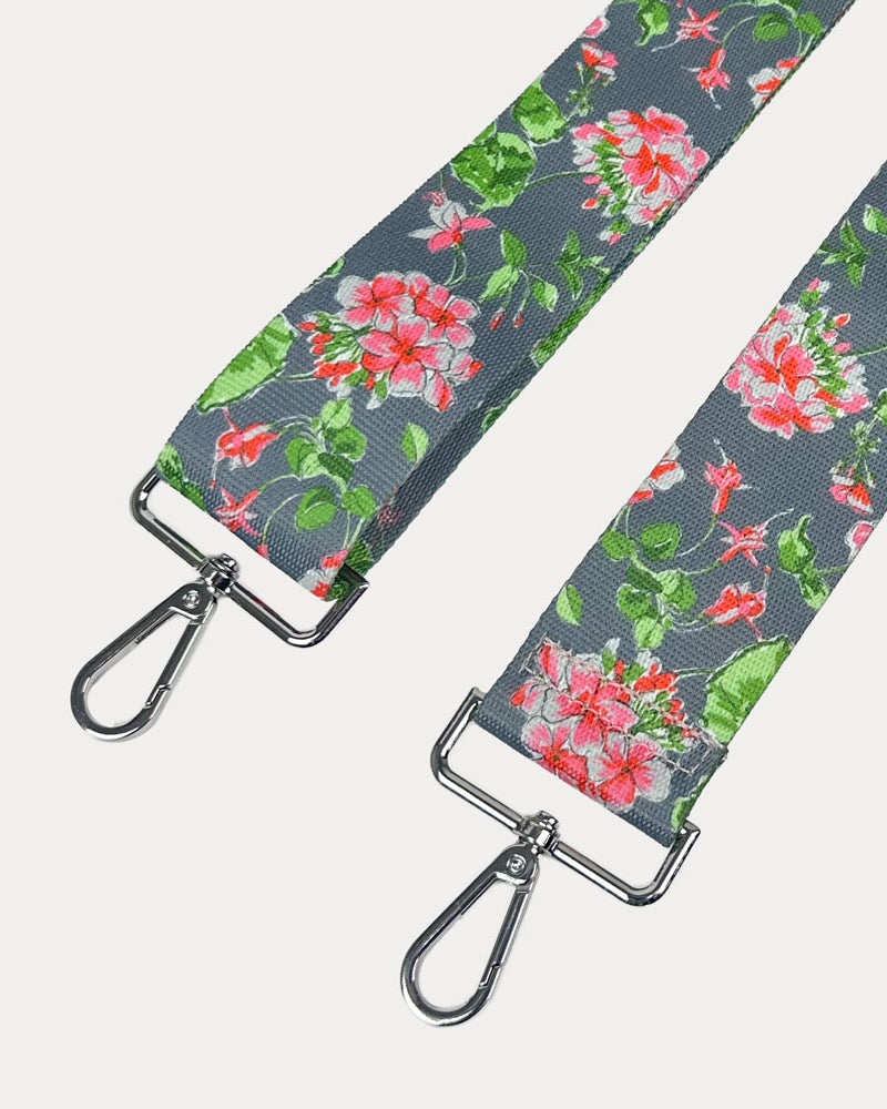 Grey ground floral patterned strap with silver hardware on a light gray background