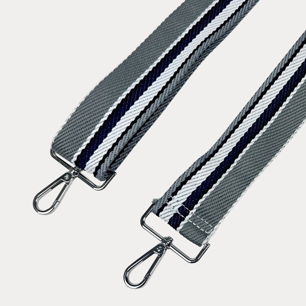 Grey, White, and Navy striped bag strap with silver hardware light gray background