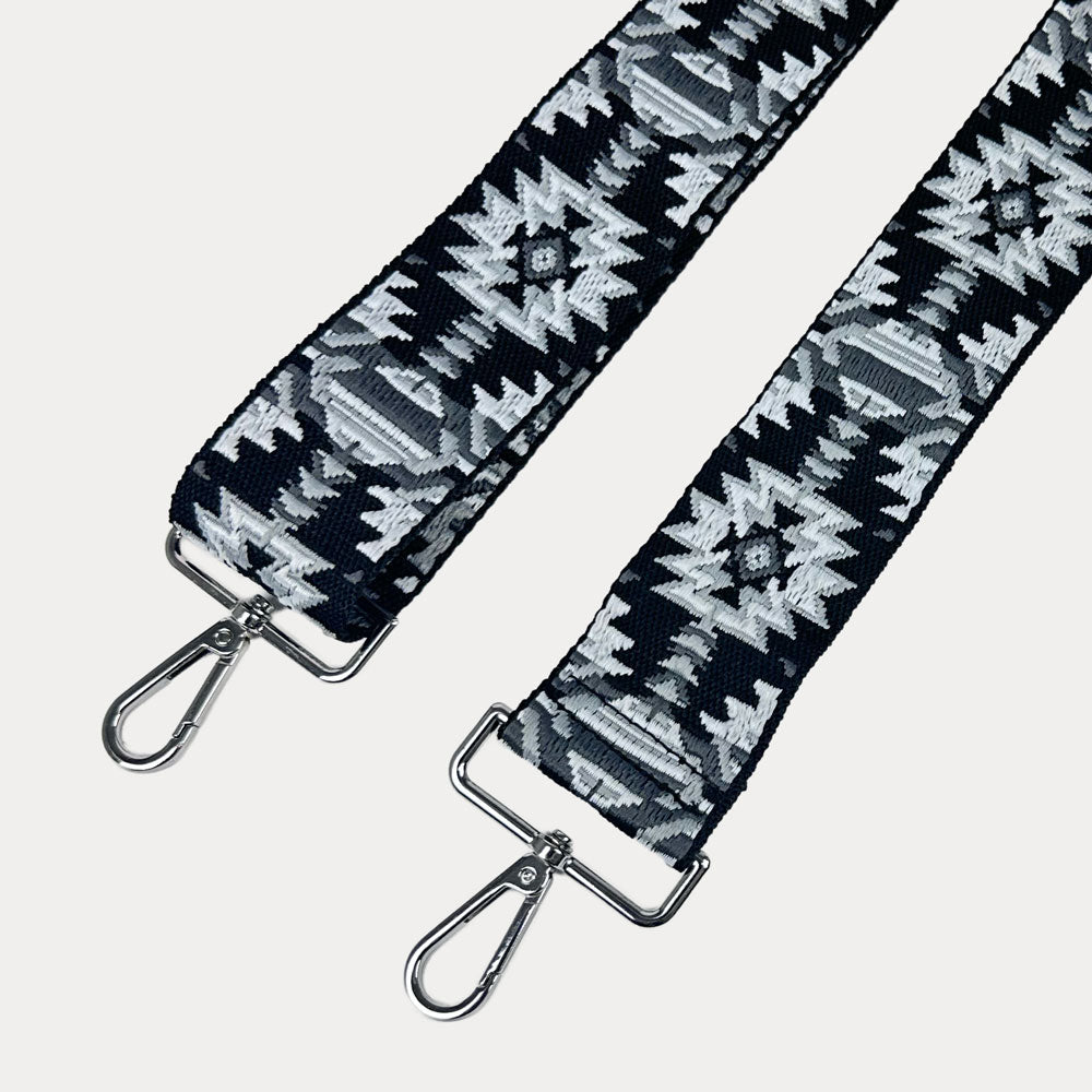 Black and white patterned strap with sliver hardware on a light gray background