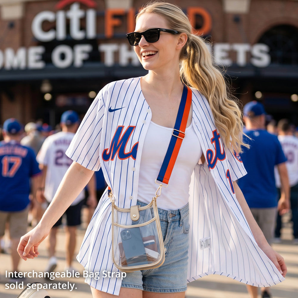 Woman outside a baseball game, wearing a clear messenger bag with a striped bag strap.