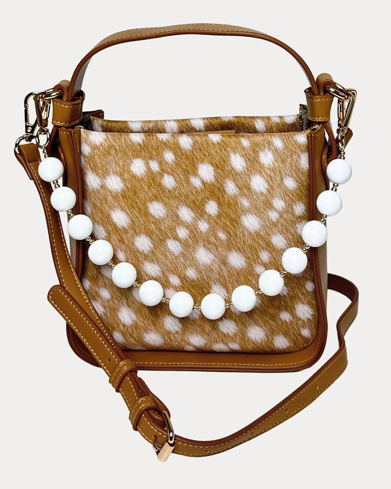 Handbag with deer pattern vegan suede and camel vegan leather details on a beige background