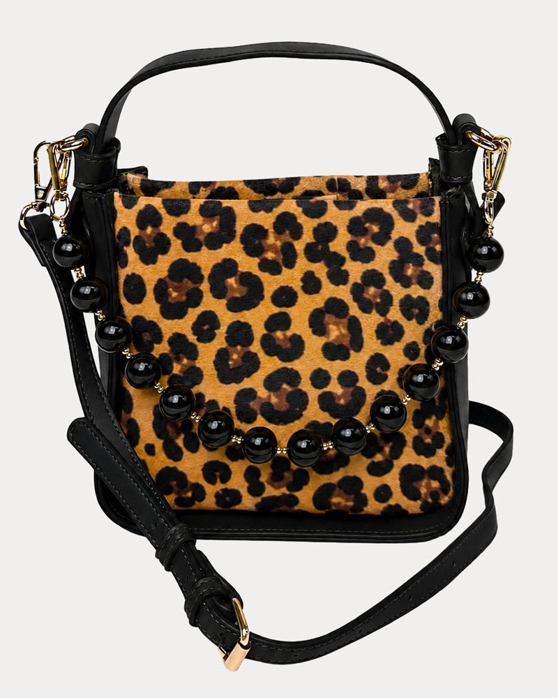 Handbag with leopard pattern vegan suede and black vegan leather details on a beige background
