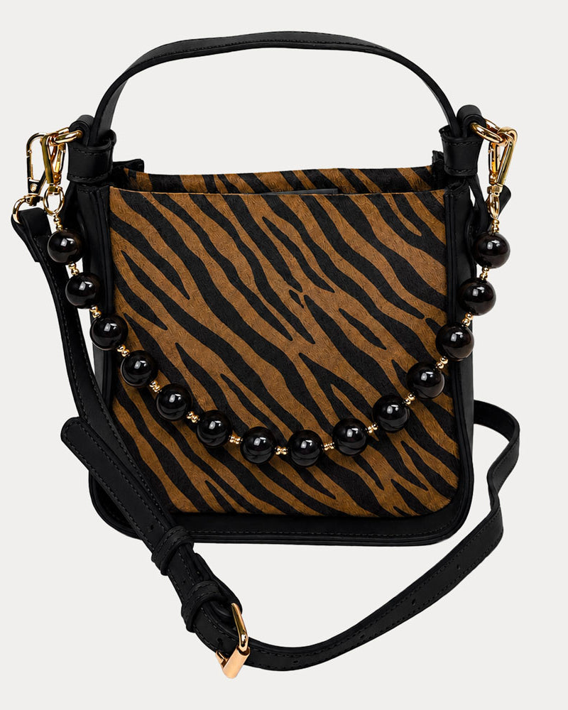 Handbag with zebra pattern vegan suede and black vegan leather details on a beige background