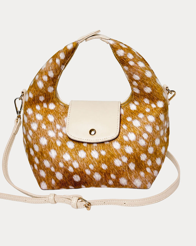 Handbag with deer print vegan suede and cream leather accents on a light gray background