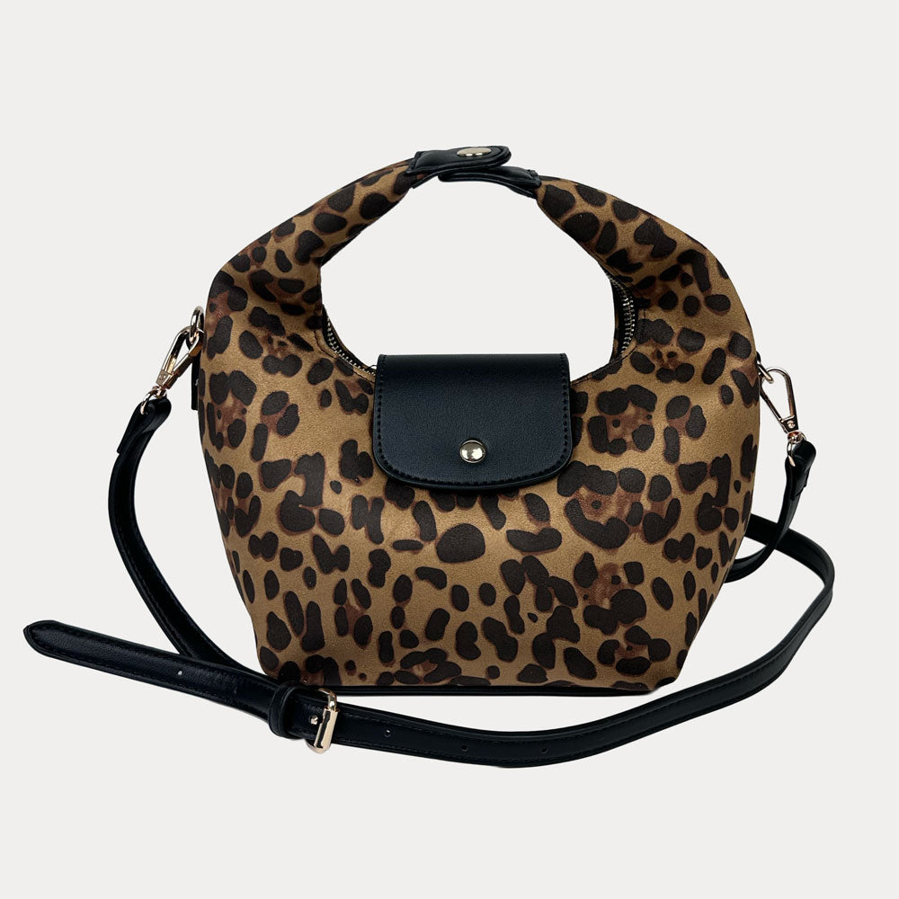 Handbag with leopard print and black vegan leather accents and a black vegan leather bag strap on a light gray background