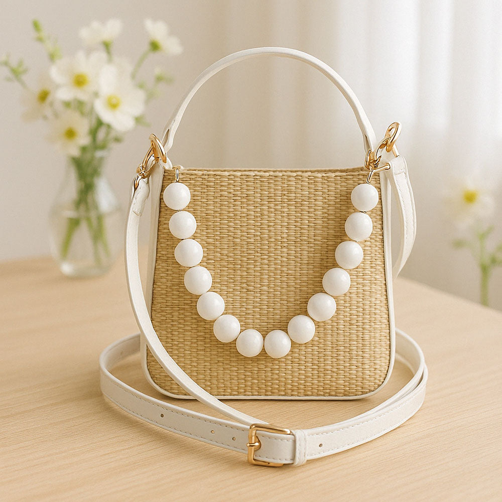 Woven handbag with white bead detail on a table with flowers