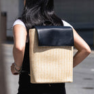 woman wearing the chelsea raffia backpack in black