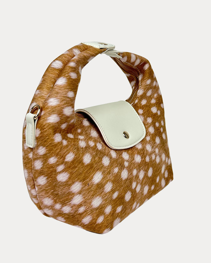 Handbag with deer print and cream leather accents on a light gray background- Side View